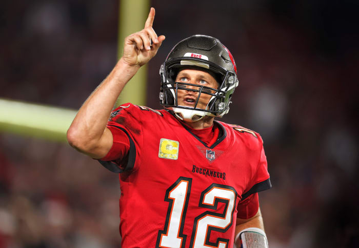 Tom Brady points to the sky as he runs on the field for a Bucs game